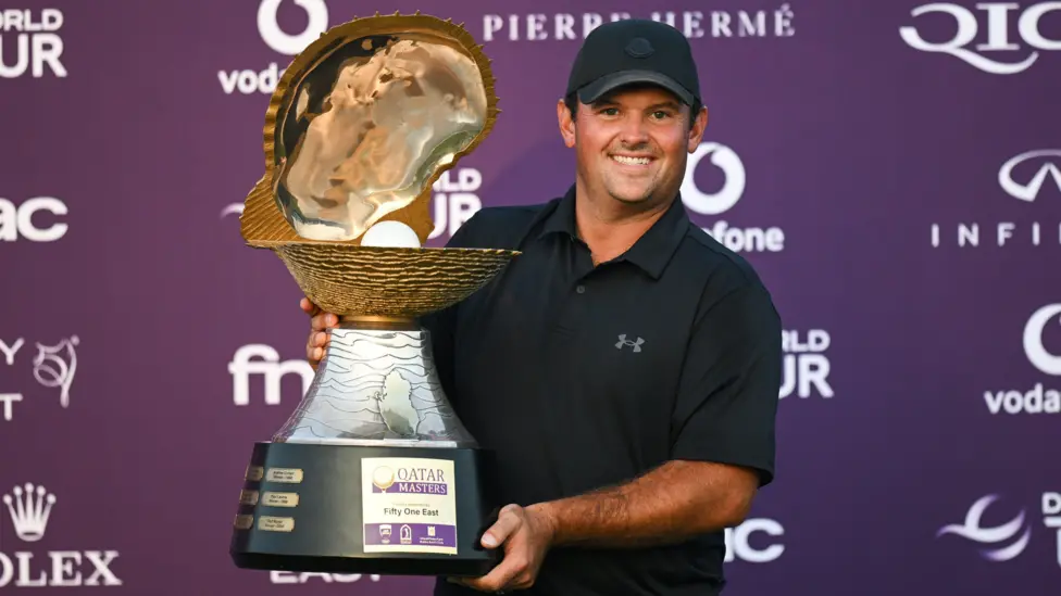 Golfer Patrick Reed smiles as he poses with the Qatar Masters 2026 trophy
