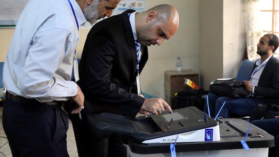 Iraqi election officials check an electronic vote-counting machine in Baghdad on 12 May 2018