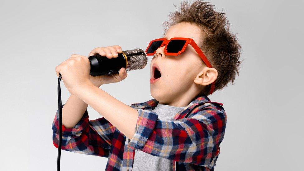 Boy-in-shades-singing-microphone.