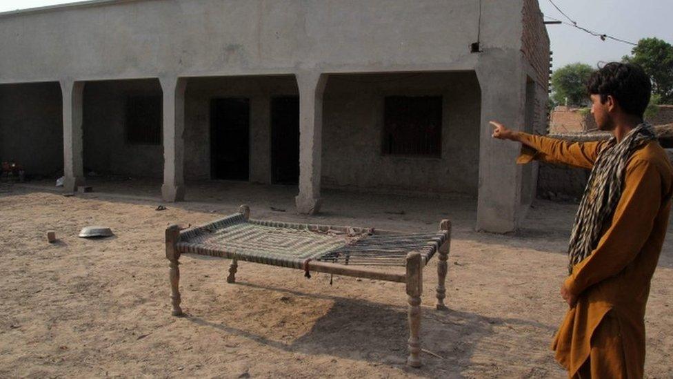 A Pakistani villager points to a house where a teenaged girl was raped in the neighbourhood of Raja Ram in Muzaffarabad