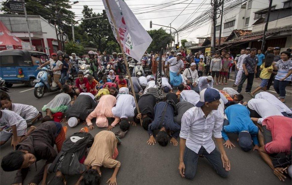 JAKARTA, INDONESIA - APRIL 19: Indonesian youths in a heavily Islamic neighbourhood pray in the main street after quick count results showed their favoured candidate decisively ahead of the incumbent on April 19, 2017 in Jakarta, Indonesia.