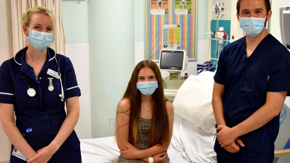 Connie in a mask alongside medical staff