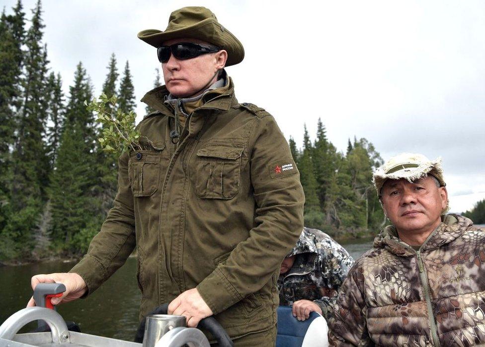 Vladimir Putin (left), accompanied by Sergei Shoigu, guides a boat in the remote Tuva region in southern Siberia, August 2017