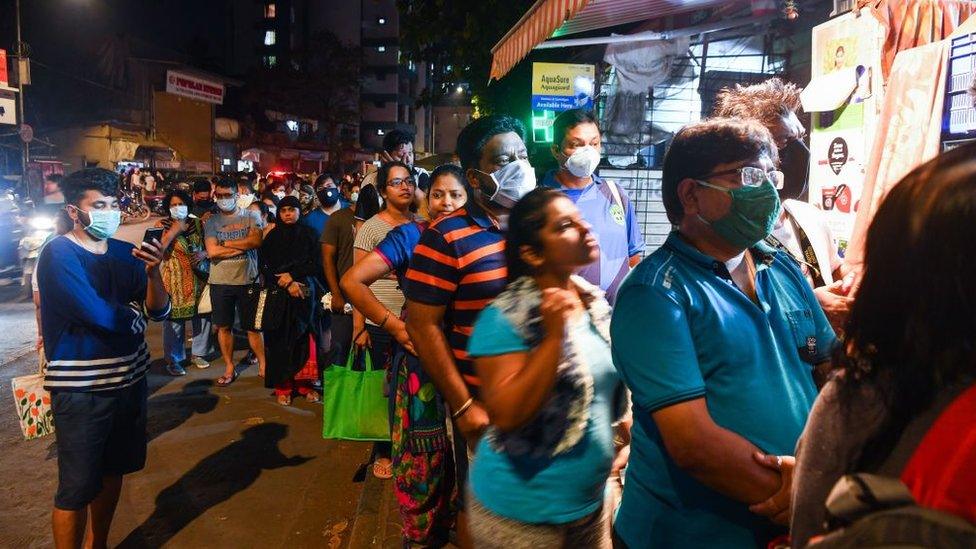 People lineup outside a store to buy groceries following Indian Prime Minister's announcement of a government-imposed nationwide lockdown as a preventive measure against the COVID-19 coronavirus in Mumbai on March 24, 2020.