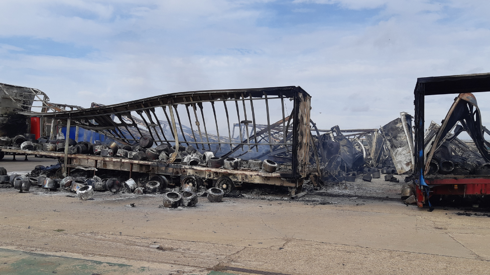 The charred metal frames of the trailers