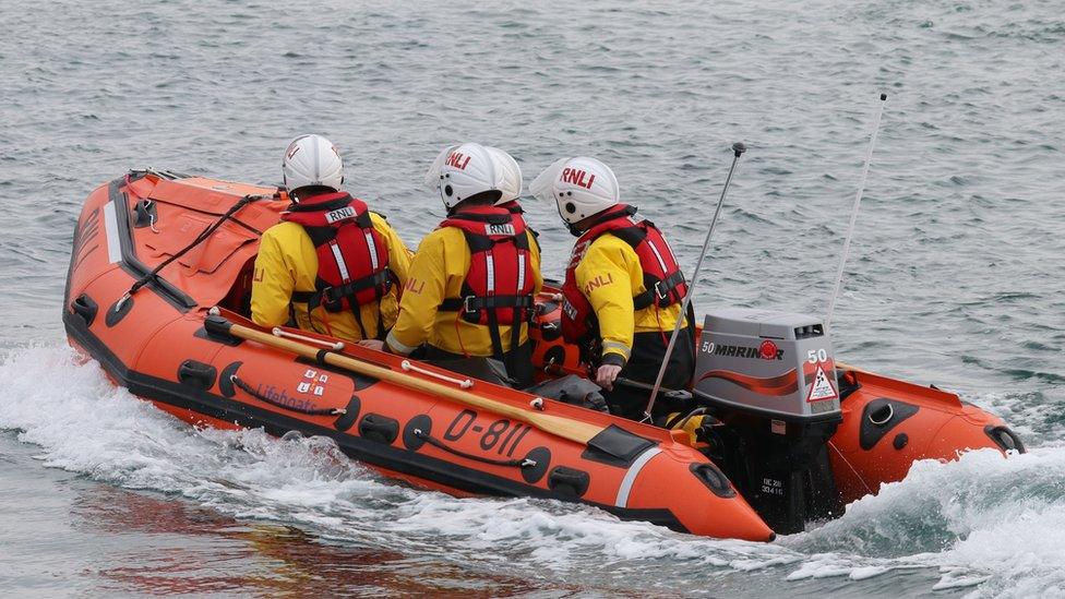 Criw RNLI ar y dwr yn Mhwllheli