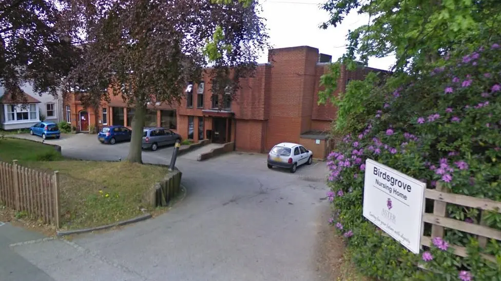 A general view picture of the nursing home, a two-storey brick building with cars four cars parked outside the entrance area.