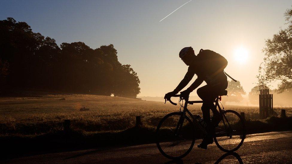 Cyclist silhouetted as they ride their bike