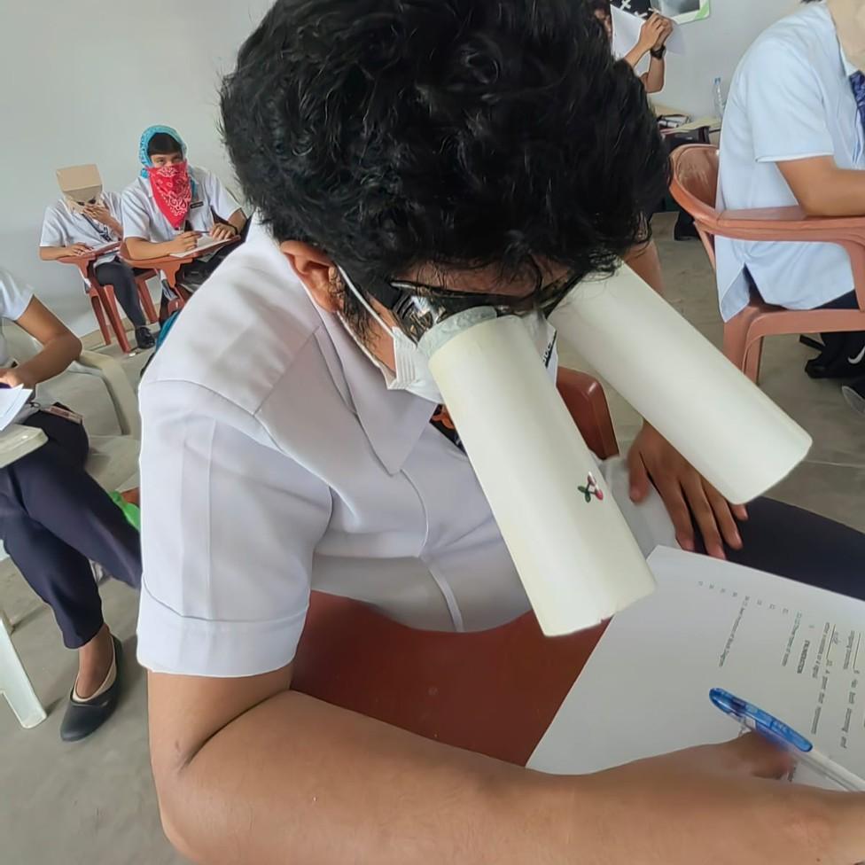 A student wears homemade goggles during a college exam in the Philippines