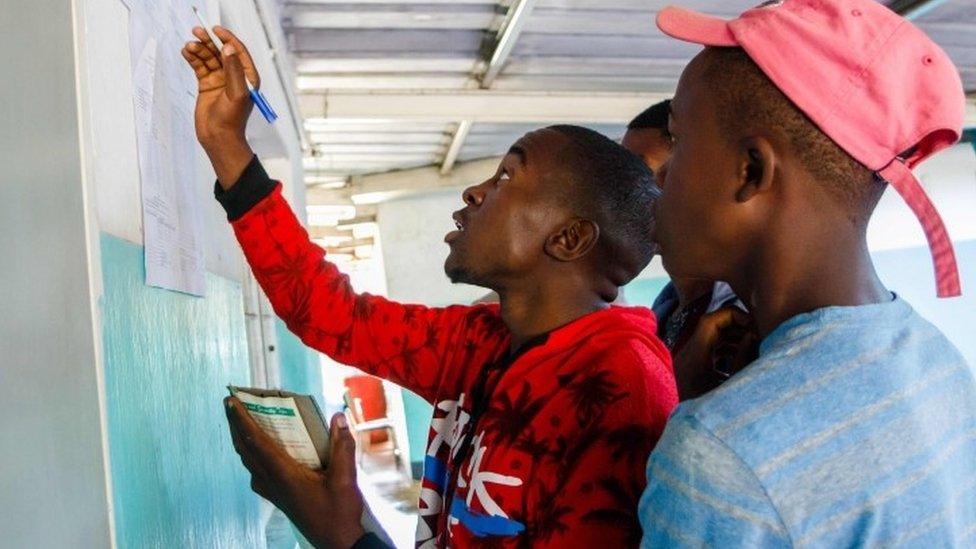 People gather a day after elections to look at ballot count results posted out side each polling station after vote counting was completed overnight, on July 31 2018 in Kambuzuma Township, Harare