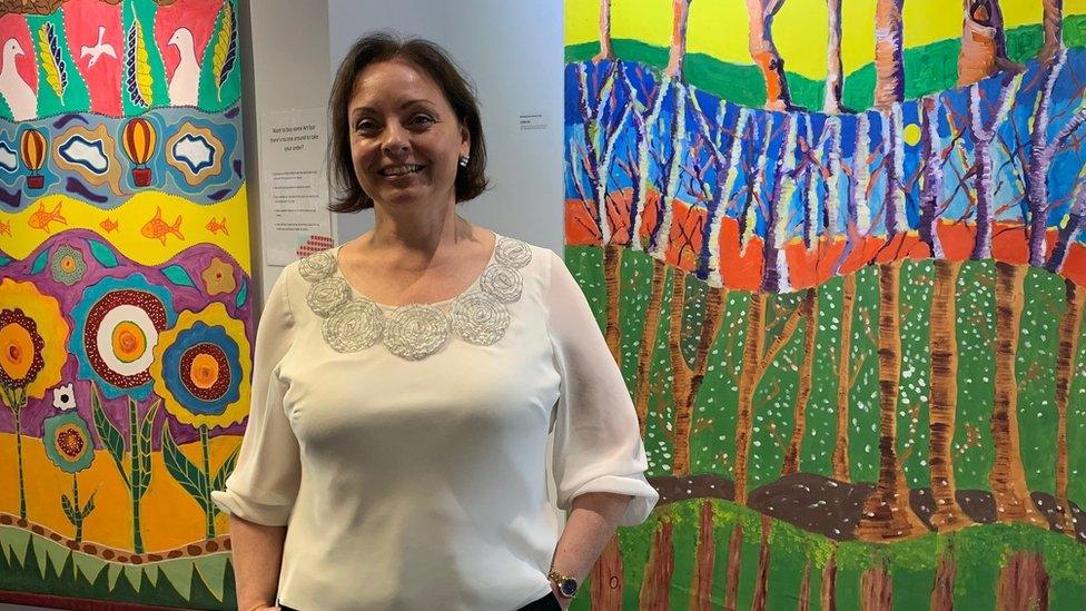 Director of The Engine House Jane Hall in front of two of the paintings