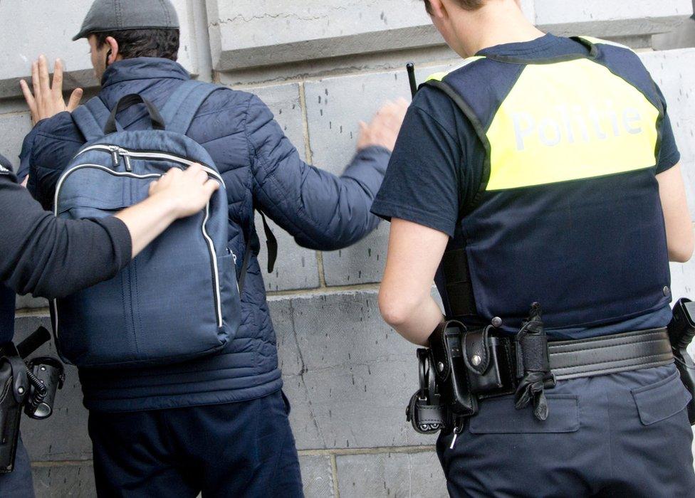 Police search a man's backpack at a station in Antwerp, 18 June