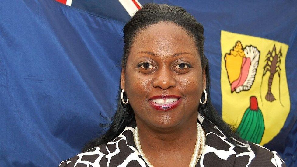 Rhondalee Braithwaite-Knowles standing in front of a flag