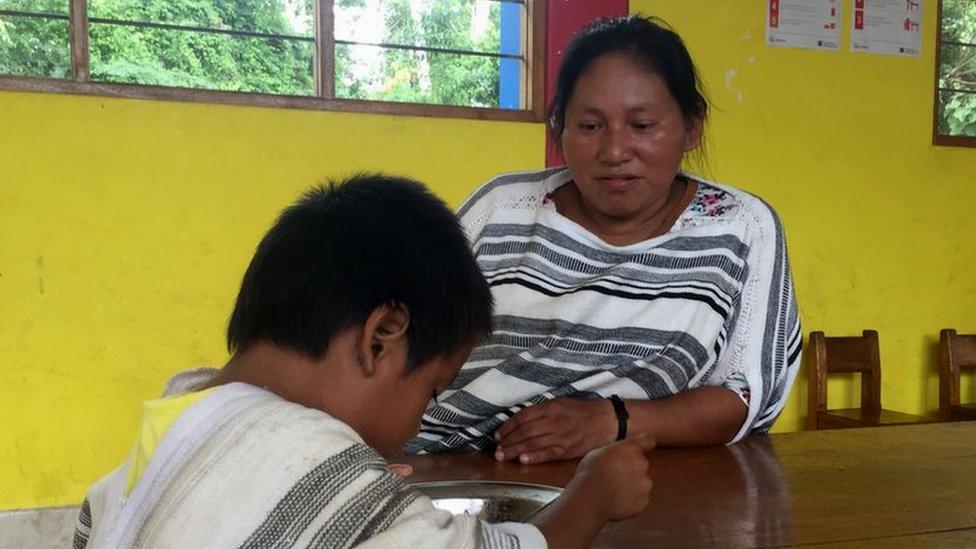 Romelia Rivera Italiano teaches a child at the local school