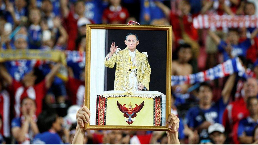 A soccer player from the Thai national team displays a picture of Thailand"s King Bhumibol Adulyadej after winning the "King"s Cup" at Rajamangala stadium in Bangkok, Thailand, June 5, 2016.