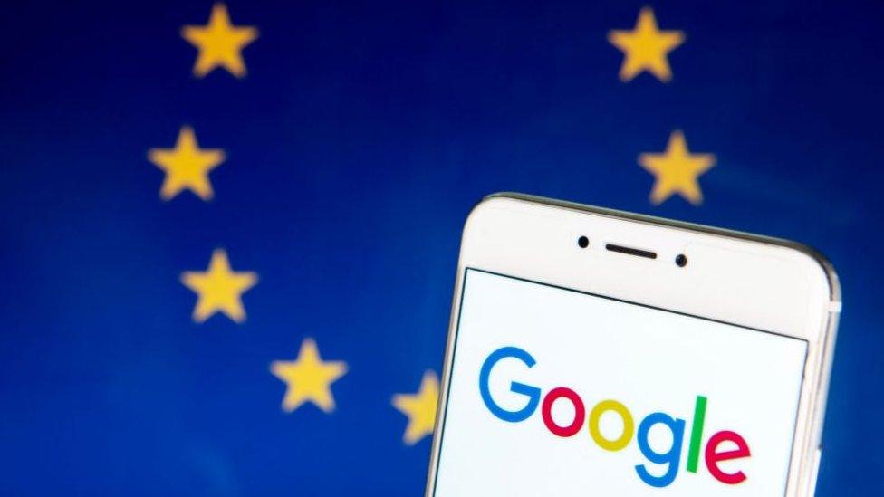 The Google logo on a smartphone with the EU flag in the background