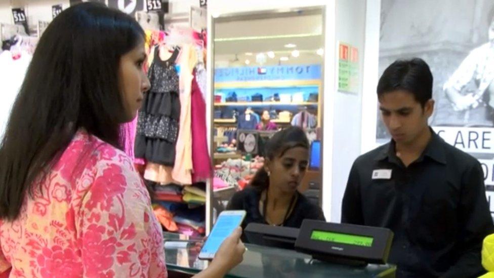 Woman about to pay by mobile phone