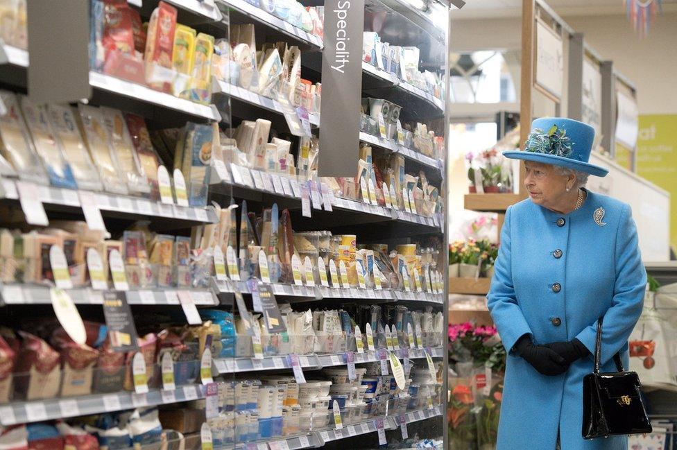 Queen Elizabeth II looks at products on the shelves at a Waitrose supermarket during a visit to the town of Poundbury on 27 October 2016