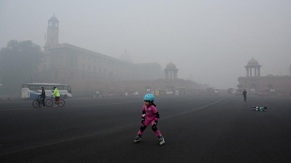 Children doing skating in heavy smog near the president house in New Delhi