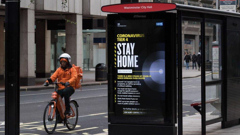 A cyclist passes a tier 4 sign on a bus stop