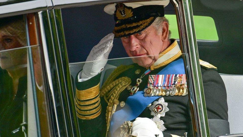 King Charles saluting from a car