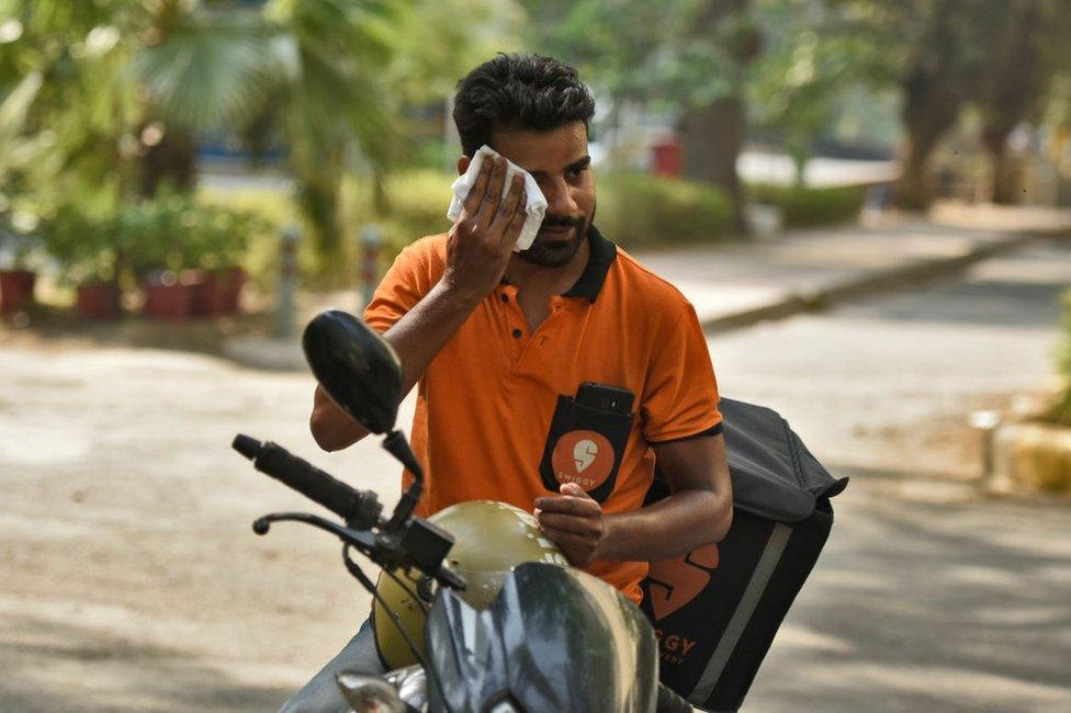 A delivery boy wipes off his sweat on a hot day as temperature rises above 45 degree celsius, on June 2, 2019 in New Delhi, India.