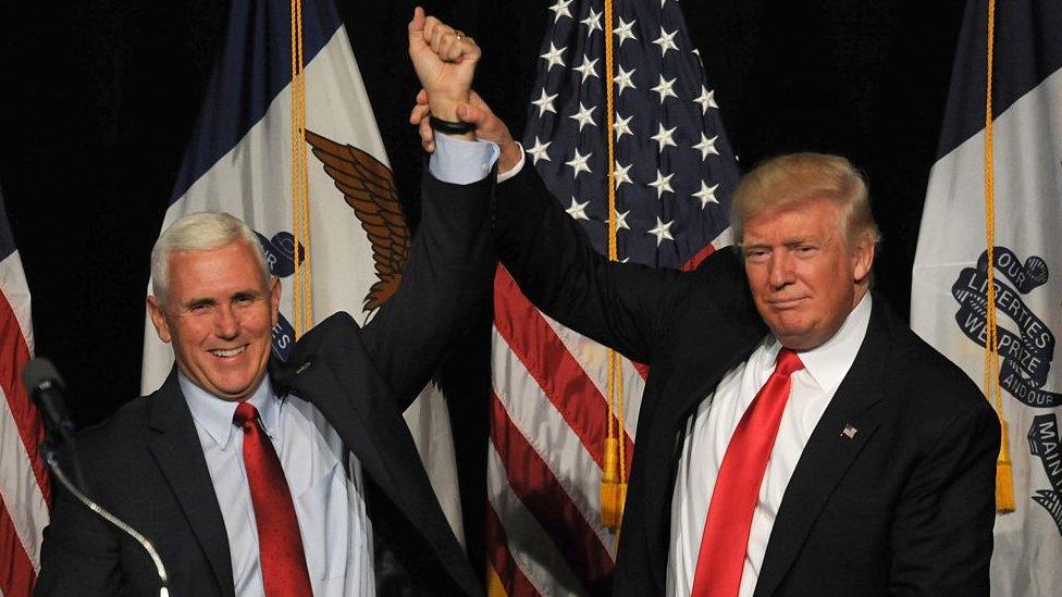 Mike Pence and Donald Trump raise arms at an Iowa rally in August