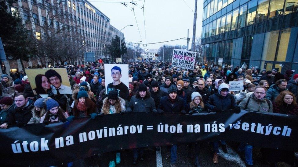 Marchers with the banner saying "an attack on journalists is an attack on us all"