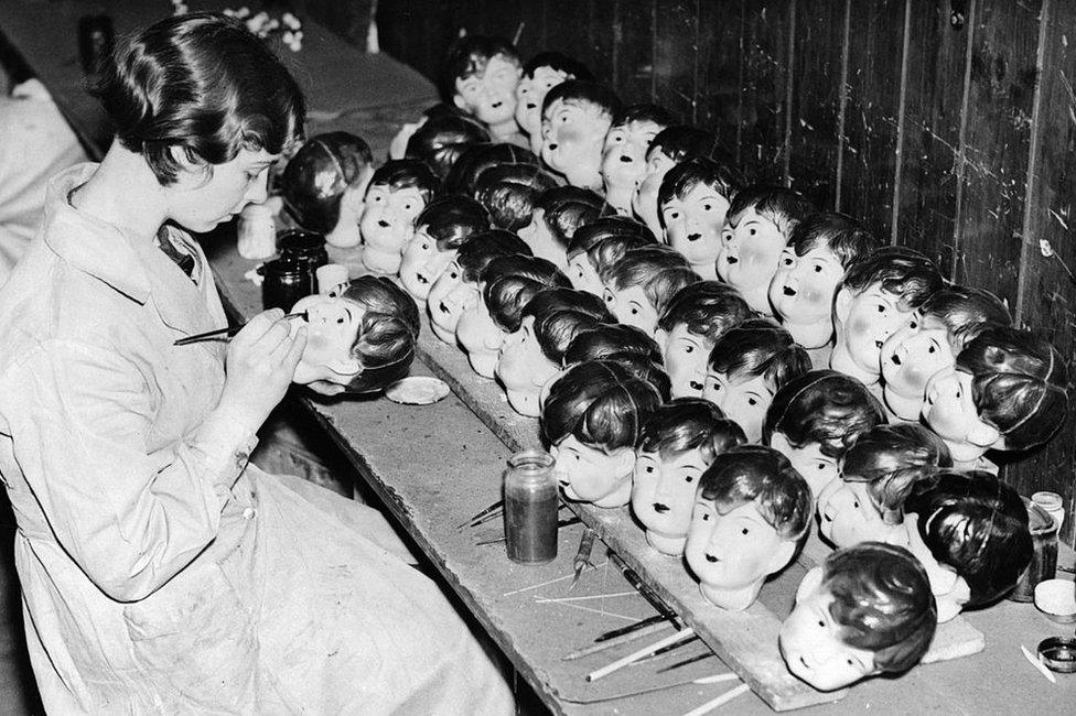 A worker painting celluloid dolls heads at a factory in Leicester in 1935