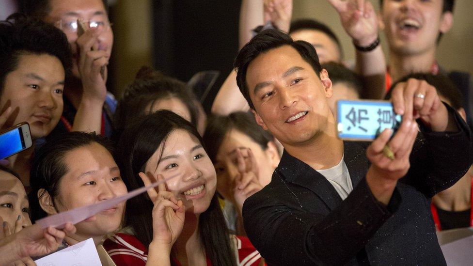 Actor Daniel Wu poses for a selfie with Chinese fans at a red carpet event for the movie "Warcraft" in Beijing, China, Wednesday, June 1, 2016.