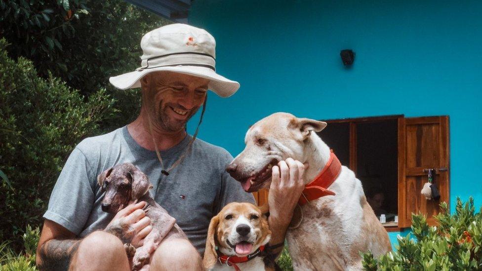 Niall Harbison with several of the dogs he has rescued at his home in Thailand