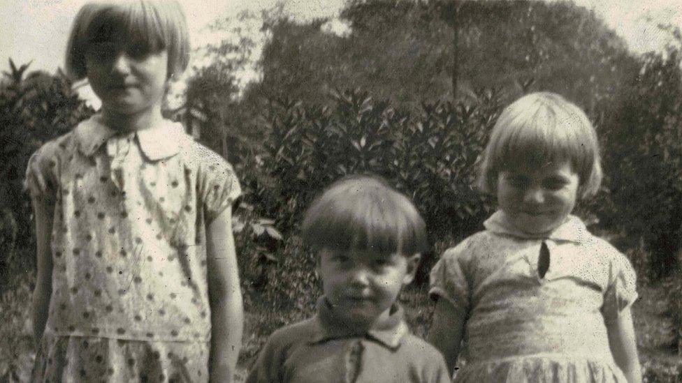 Trio of children pose for camera