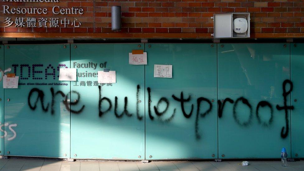 Graffiti underneath a sign in the university that says "Ideas" that adds: "are bulletproof"