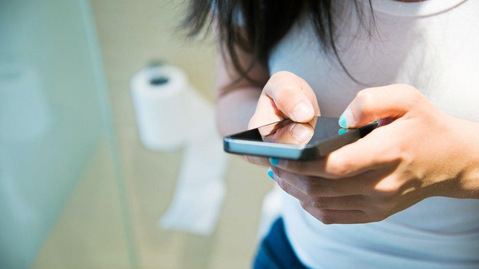 woman-uses-phone-on-toilet.