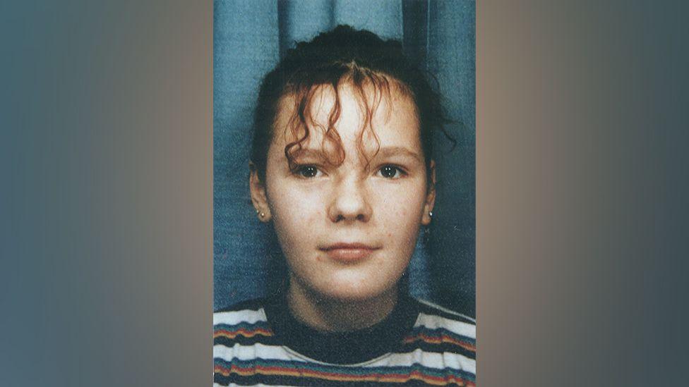 A close-up passport style photo of Lindsay Rimer with tied up curly hair, believed to have been taken when she was around 13 years old.