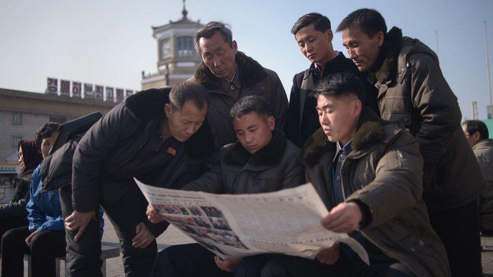 People read the Rodong Sinmun newspaper showing coverage of North Korea's leader Kim Jong Un visiting Vietnam for a summit in Hanoi with US President Donald Trump, in a public square in Pyongyang on February 28, 2019.