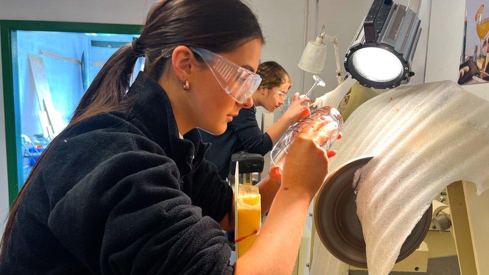 A group of teenage apprentices are learning the craft of glass cutting