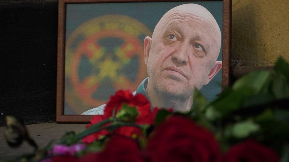 People lay carnations to a memorial as they pay tribute to Yevgeny Prigozhin