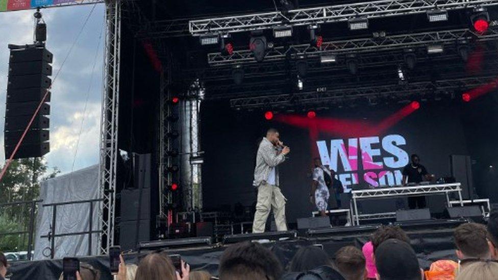 Performer at a music festival on a stage during the daytime