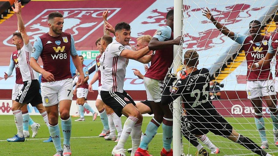 Orjan Nyland of Aston Villa fumbles and pulls the ball from behind the line