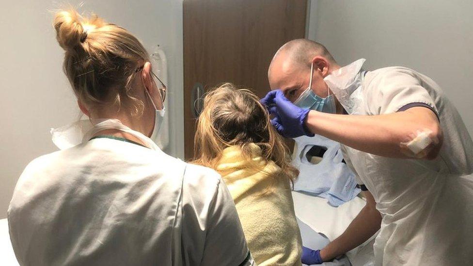 A physiotherapist helps a stroke sufferer to stand