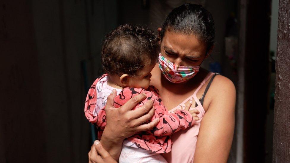 Luciana holding her nine-month-old daughter