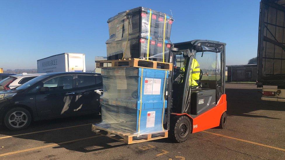 Forklift carrying crates full of supplies