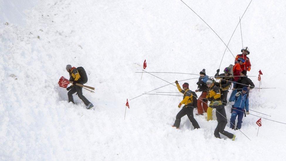 Rescue forces and helicopters search for missing persons after an avalanche swept down a ski piste in the central town of Andermatt in canton Uri, Switzerland