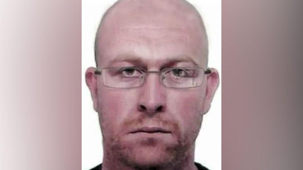 Police image of how fugitive Kevin Parle wearing glasses and with short red hair and stubble may look after years on the run