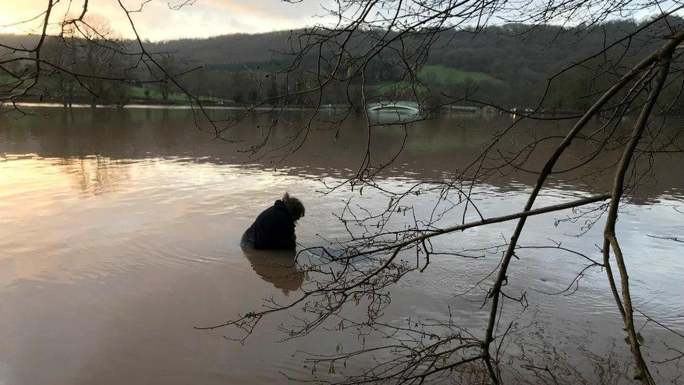 Woman trapped on roof of her car in flood water