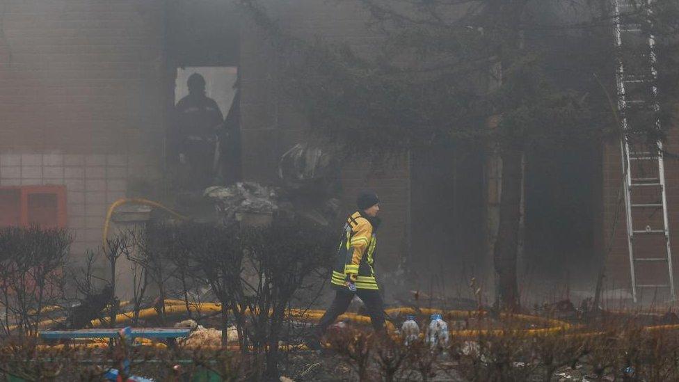 Emergency personnel work at the site of a helicopter crash, amid Russia's attack on Ukraine, in the town of Brovary, outside Kyiv, Ukraine