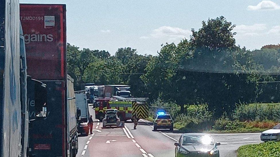 Traffic in a queue near the site of the incident with emergency services on the road