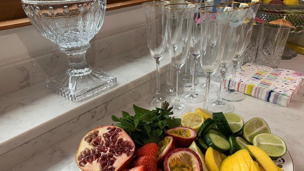 A plate of fruit, champagne flutes and happy birthday napkins