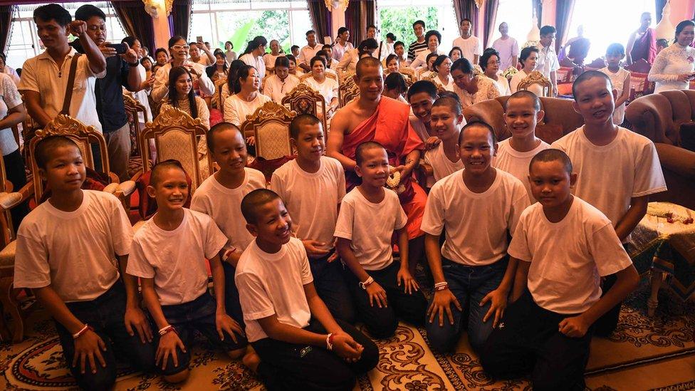 Thai coach Ekkapol Chantawong (C) and all 12 members of the "Wild Boars" football team pose for a photo together after a ceremony to mark the end of the 11 players's retreat as novice Buddhist monks